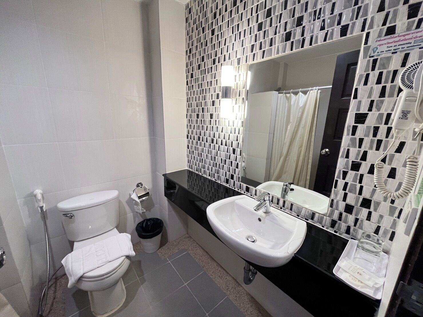 A modern bathroom with a toilet, sink, and shower.