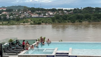 Una piscina al aire libre, sillones reclinables de piscina