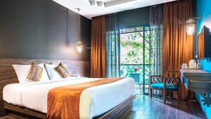 Habitación de hotel moderna con una cama grande, cabecero de madera y vista a zonas verdes por la ventana.