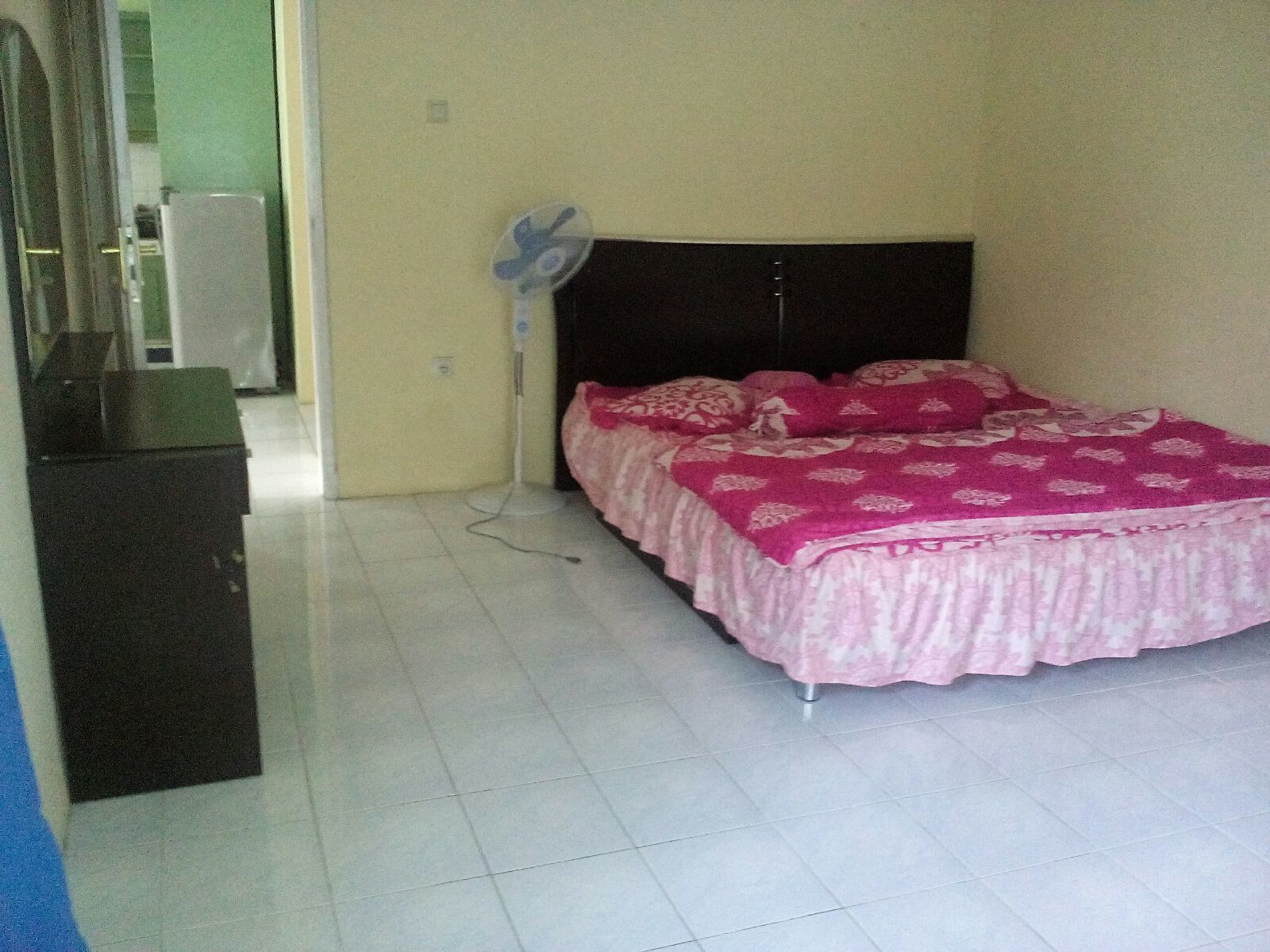 Un dormitorio con cama, ventilador y escritorio.