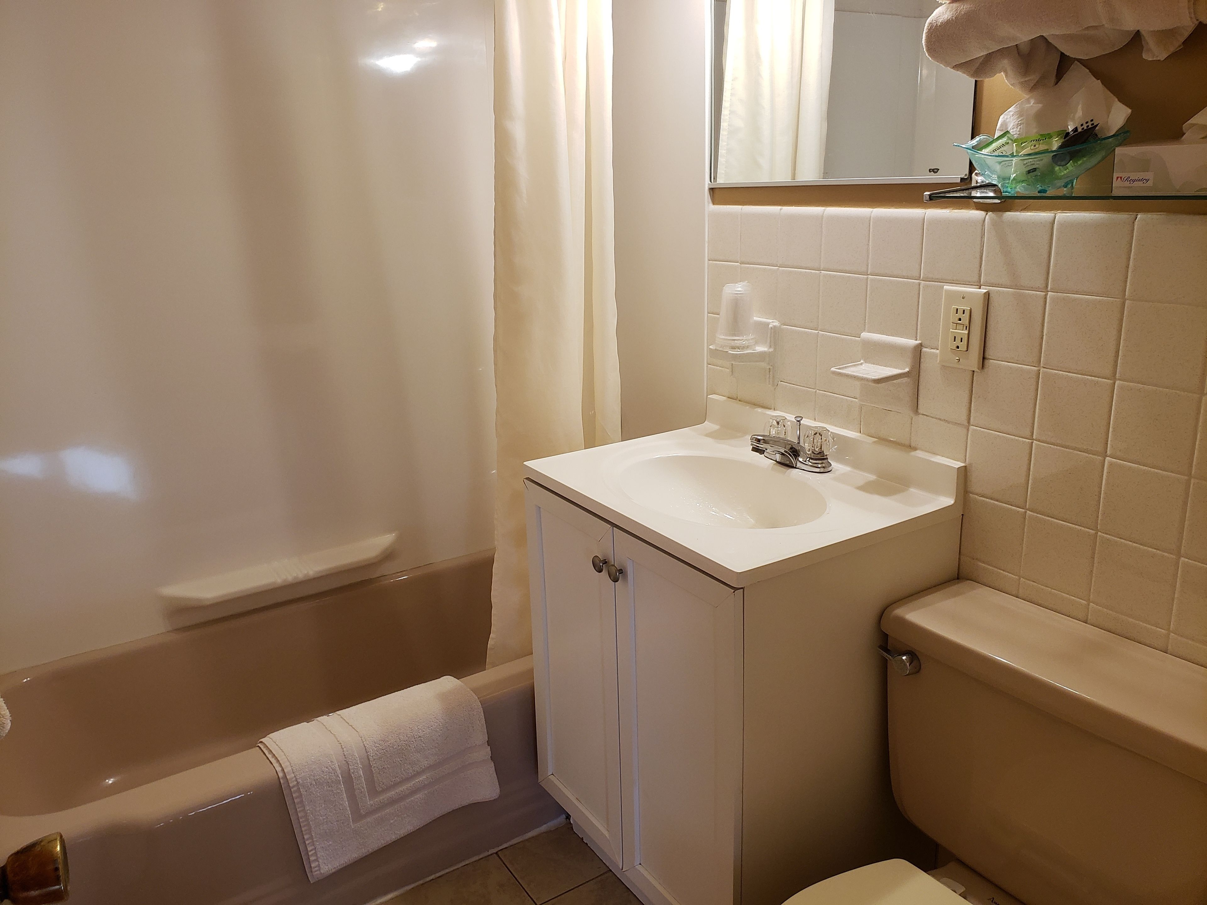 Un baño con bañera, lavamanos e inodoro.