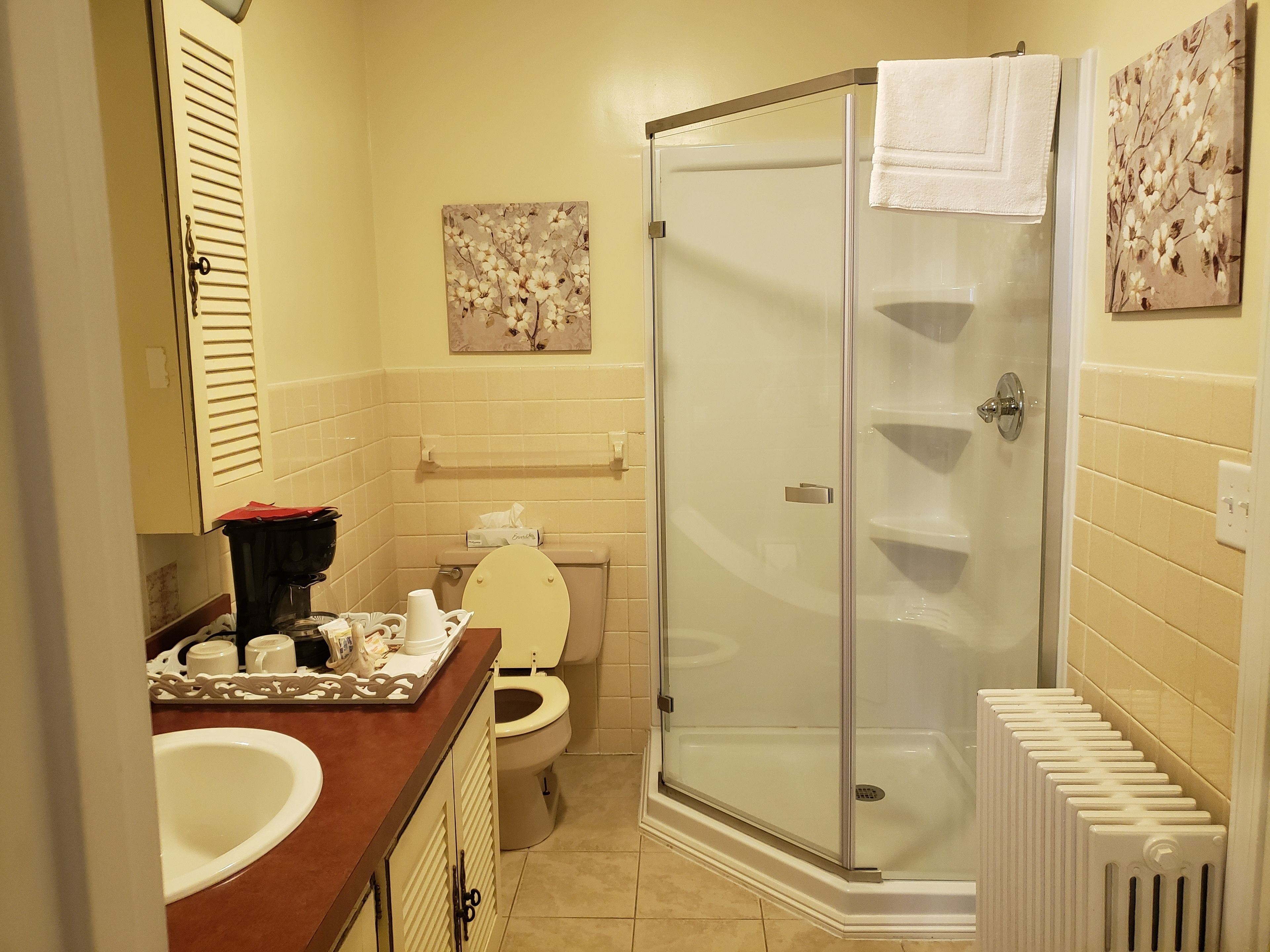 Ein Badezimmer mit Toilette, Waschbecken, Dusche und Handtuchhalter.