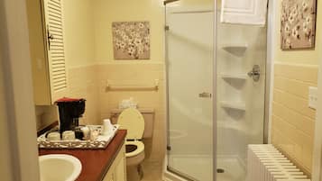 Ein Badezimmer mit Toilette, Waschbecken, Dusche und Handtuchhalter.