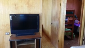 Una puerta de madera con un televisor sobre un soporte en primer plano.