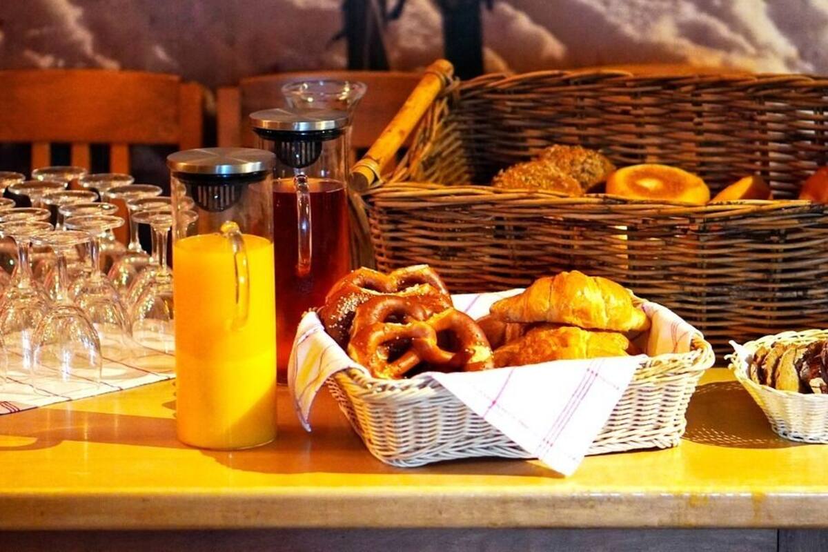Et morgenbord med glas, appelsinjuice og bagværk.