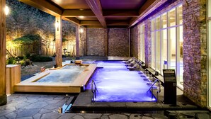 Un área de spa con varios jacuzzis y una pared de piedra.
