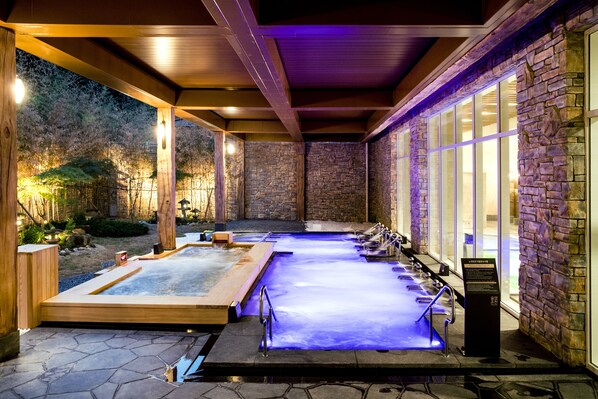 A spa area with multiple hot tubs and a stone wall. - Sono Belle Cheongsong (Cheongsong)