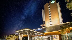 A modern hotel with a prominent tower and a star logo, featuring a covered entrance and a well-lit facade. - Sono Belle Cheongsong (Cheongsong)