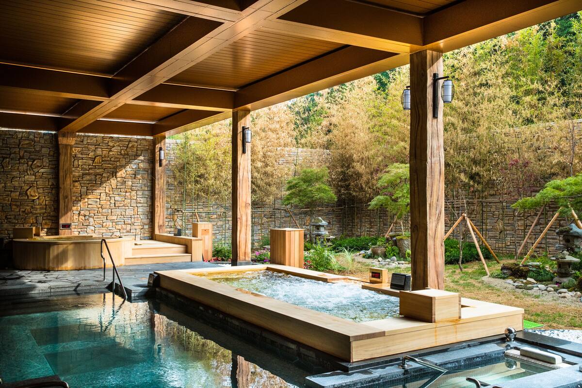 En traditionel japansk onsen med træbænke og en baggrundsvæg af sten.