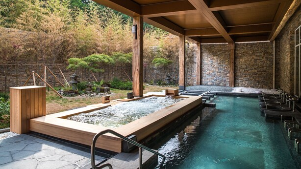 A spa area with a wooden deck, stone walls, and a pool. - Sono Belle Cheongsong (Cheongsong)