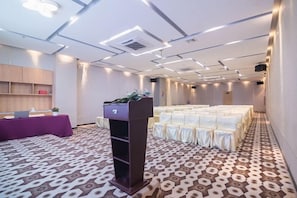 A conference room with a podium, tables, and chairs arranged for a meeting. - Jin Yatai Business Hotel (Guangzhou)