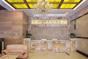 A lobby with a reception desk, a chandelier, a sofa, and a marble wall with a floral pattern. - Jin Yatai Business Hotel (Guangzhou)