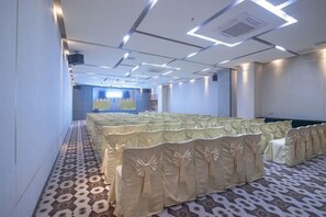 A conference room with rows of tables and chairs, a patterned carpet, and a modern ceiling design. - Jin Yatai Business Hotel (Guangzhou)