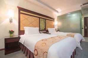 A hotel room with two beds, a nightstand, a mirror, and a wall-mounted light fixture. - Jin Yatai Business Hotel (Guangzhou)