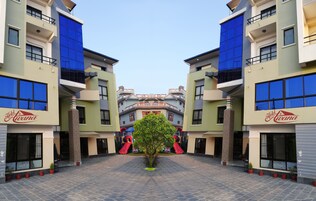 Um hotel com um pátio central, várias varandas e uma área de recreação infantil com escorregadores.