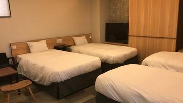 A hotel room with two beds, a desk, a chair, a TV, and a wardrobe.