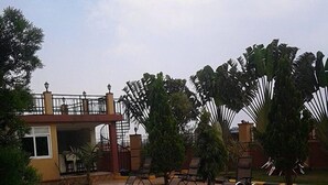 A swimming pool with lounge chairs and a covered bridge. - Makutano Hotel (Kampala)