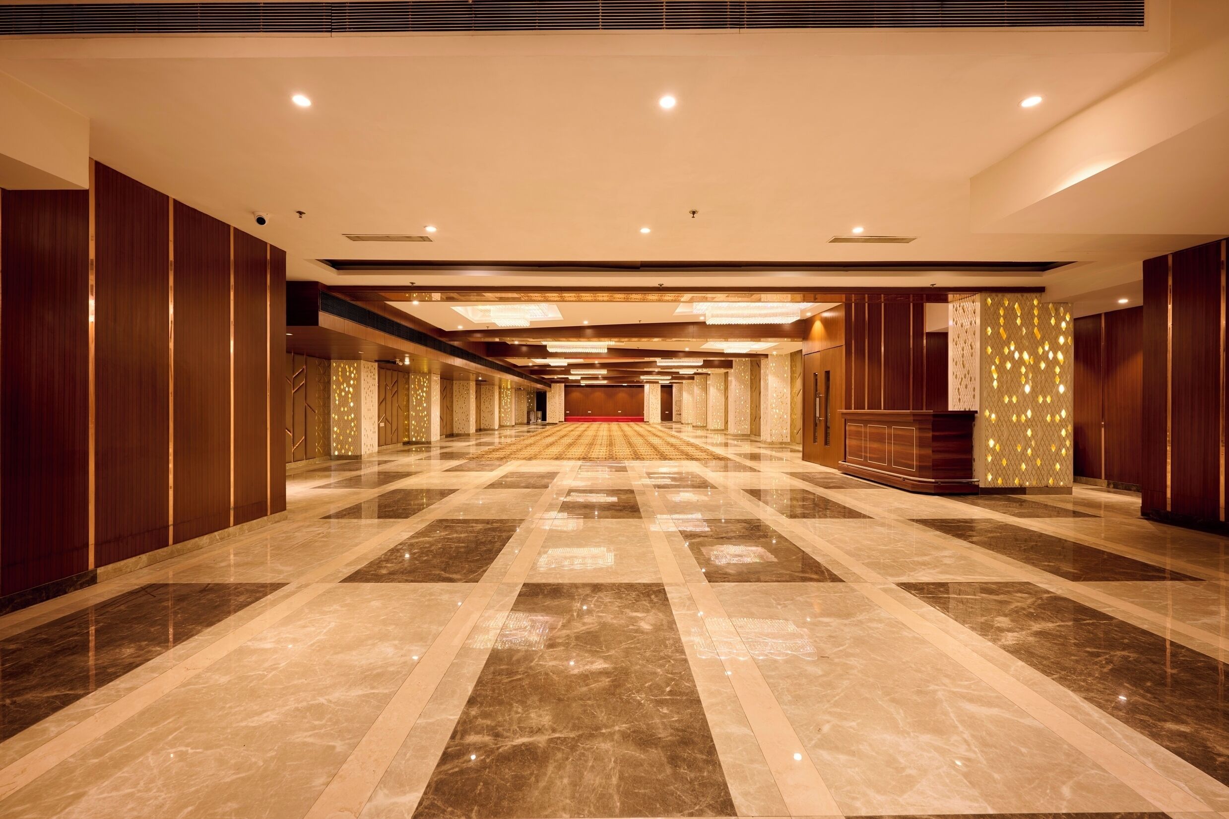 A spacious, well-lit hallway with a polished marble floor and wooden paneling on the walls.