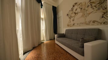 Habitación cuádruple superior | Sala de estar | Televisión de pantalla plana