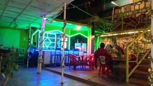 An indoor bar area with a green-lit bar counter and seating. - Colours Club Spa and Garden Resort (Kigali)