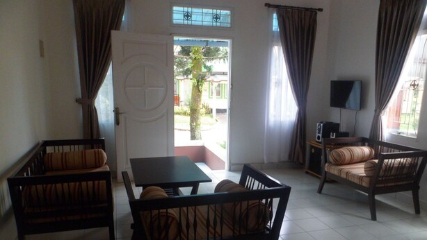 A living room with a sofa set, a table, and a TV. - Kota Bunga R (Cipanas)