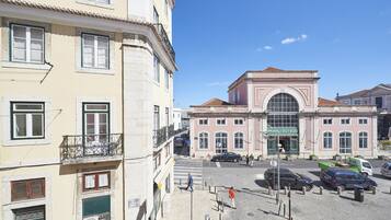 Vista de la calle con un edificio que dice "Museu do Fado" y un estacionamiento con varios coches.