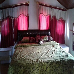 A bedroom with a large bed, a headboard, and curtains. - Kota Bunga Q (Cipanas)