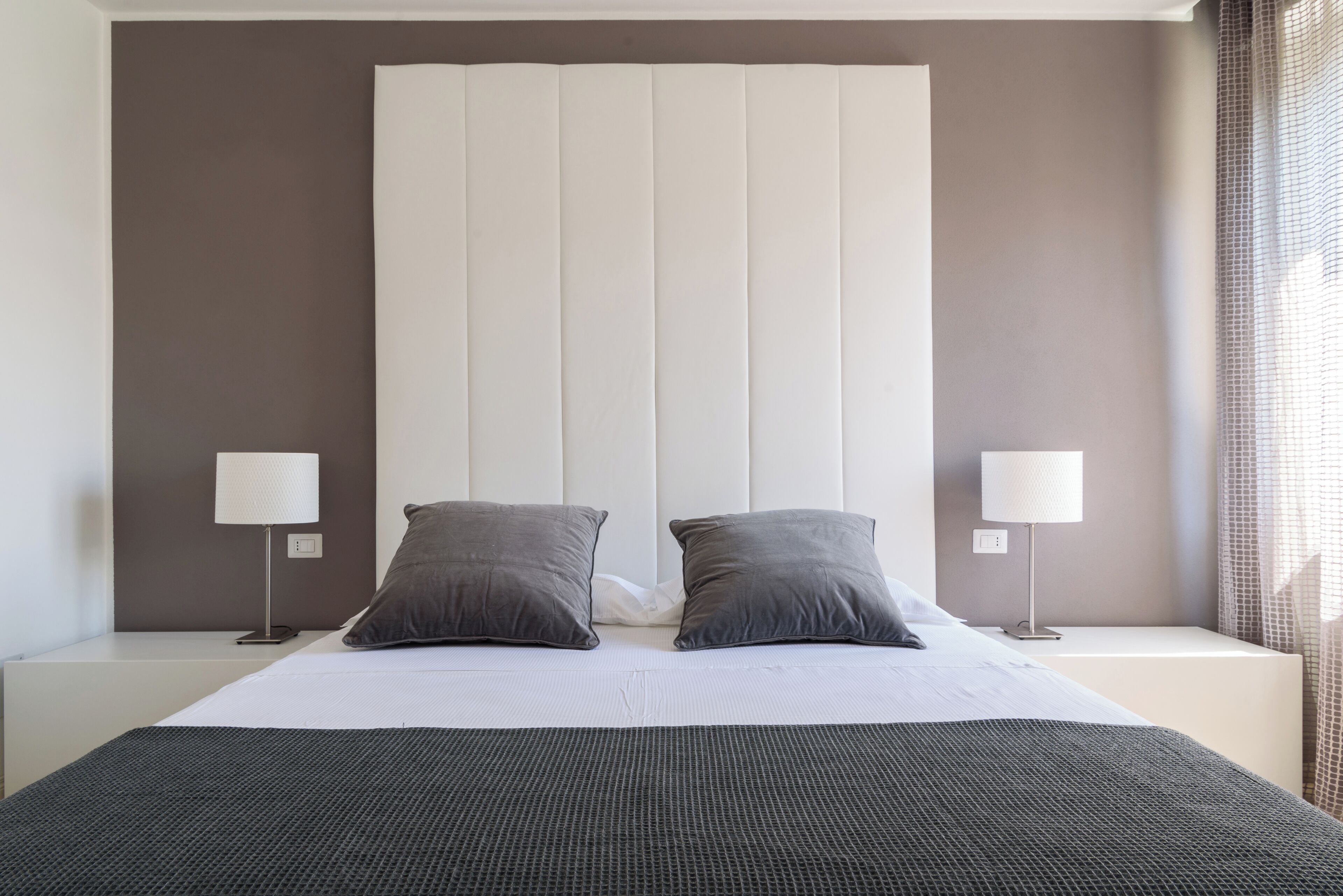 Habitación de hotel con una cama grande, dos lámparas de noche y un cabecero.