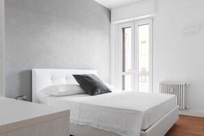 Relax in a serene bedroom with a large bed and a radiator for warmth.