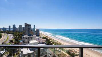 A high-rise hotel with a view of the beach and ocean.