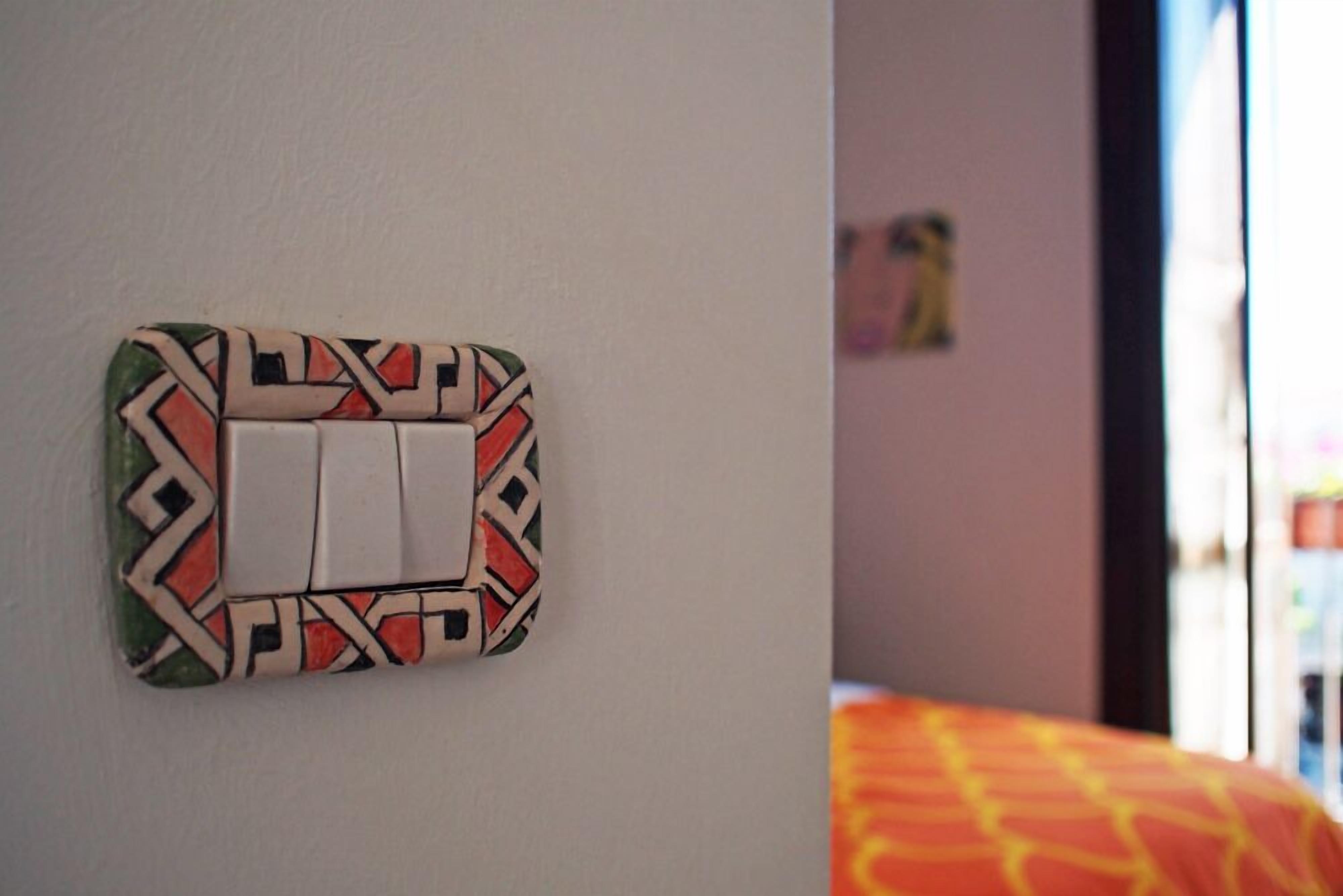 Un interruptor de luz montado en la pared con una cubierta de diseño geométrico.
