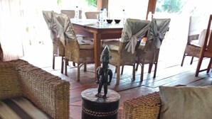 A cozy seating area with wicker furniture and a patterned rug. - Oveng Lodge (Nkolmétet)