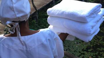 Una persona cargando una pila de toallas blancas.