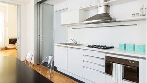 A modern kitchen with white cabinets, stainless steel appliances, and a black countertop.