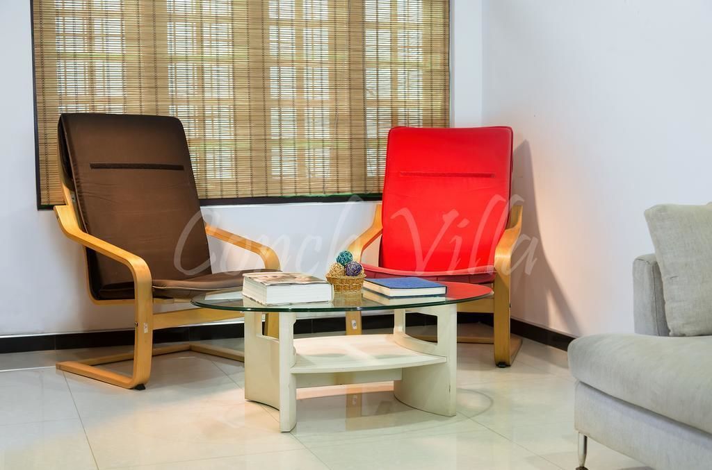 A room with two chairs, a small table, and a window with blinds.