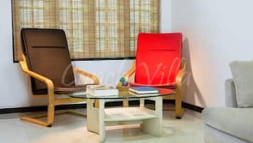 A room with two chairs, a small table, and a window with blinds.