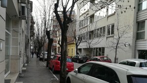 Una calle bordeada de coches aparcados y edificios.