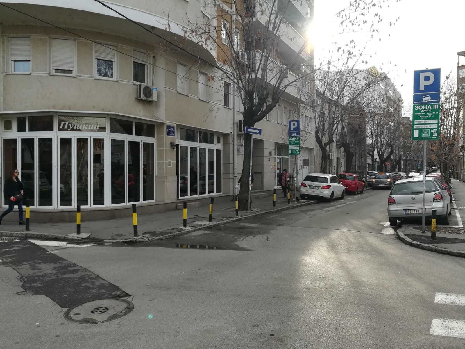 Vista de la calle con un edificio identificado como 'Hyakuni' y una señal de estacionamiento que indica una zona de aparcamiento.