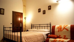 A bedroom with a bed, a chair, and a door.