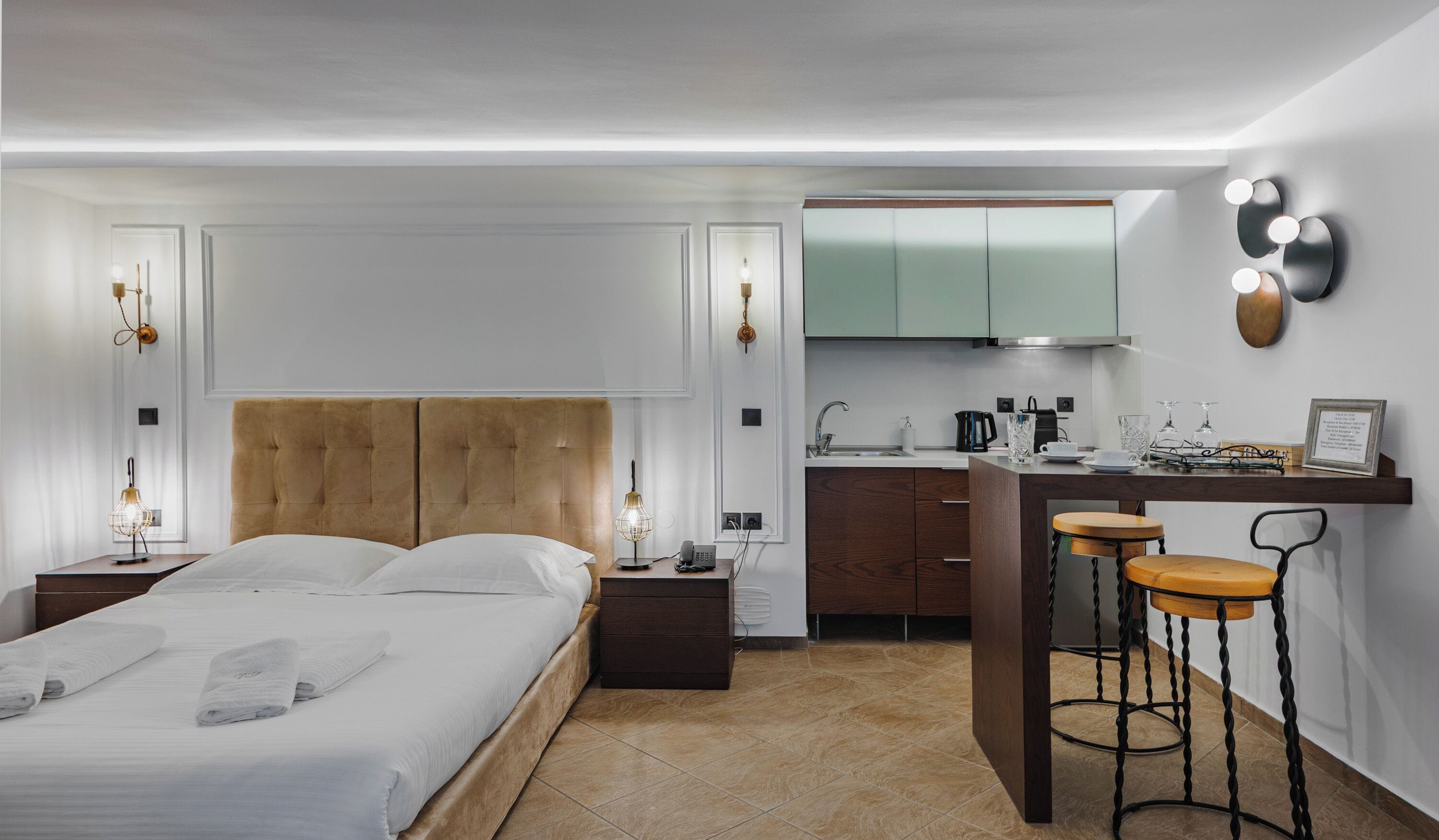 Ett modernt hotellrum med en stor säng, ett litet pentry och en barhörna.