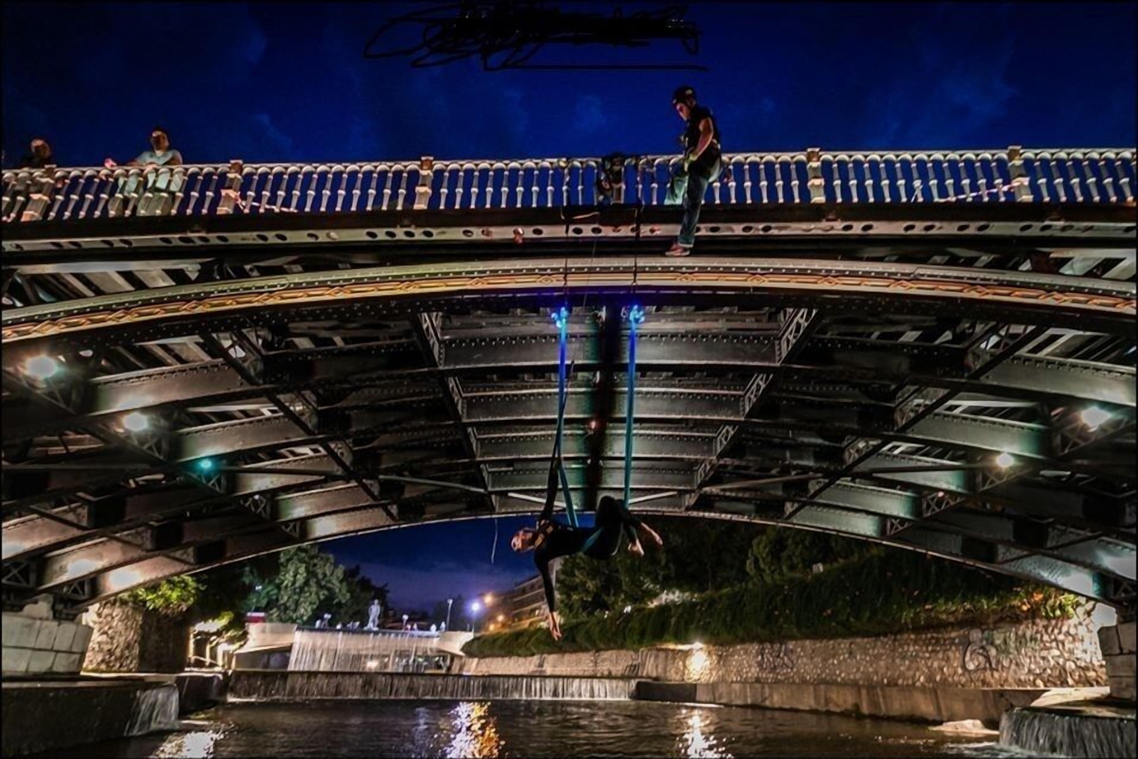A bridge with a person performing an aerial stunt.