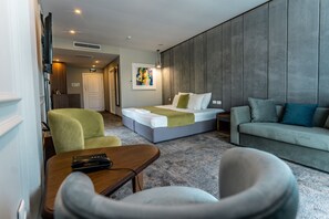 A modern hotel room with a bed, a sofa, a desk, and a chair. - Medite Spa Resort & Villas (Sandanski)