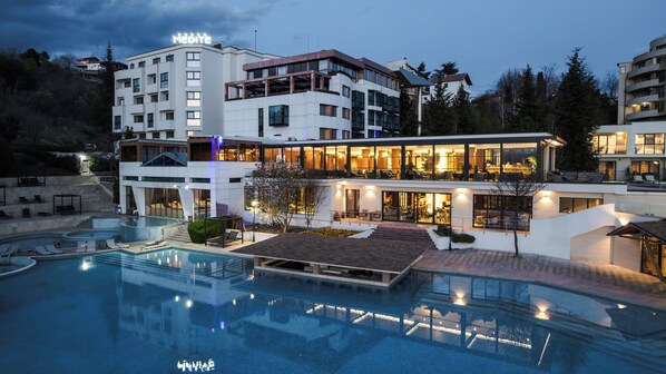 A modern hotel with a swimming pool, outdoor seating, and a well-lit facade. - Medite Spa Resort & Villas (Sandanski)