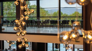 Un restaurant offrant une vue sur les montagnes et les arbres grâce à de grandes fenêtres.