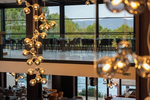Un restaurante con vistas a montañas y árboles a través de amplios ventanales.