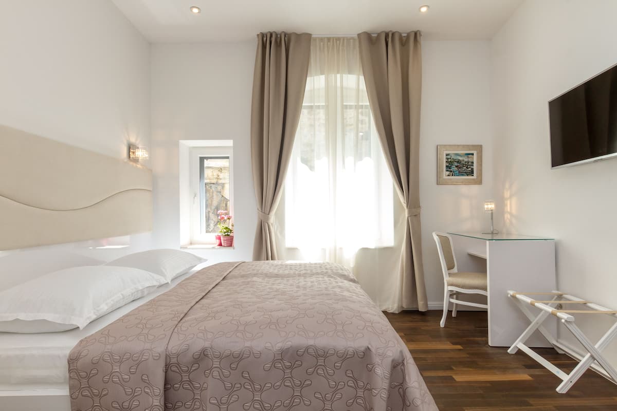 A modern bedroom with a bed, a desk, and a chair.