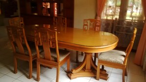 A dining table with six chairs, each with a cushioned seat. - Kota Bunga BB (Cipanas)