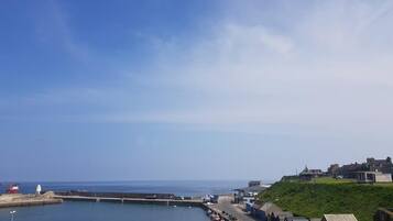 A coastal town with a marina, buildings along the waterfront, and a clear sky.