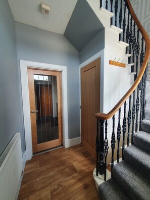 Staircase leads to a hallway with a door and wardrobe.