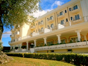 A multi-story hotel with balconies, a covered entrance, and a well-maintained lawn. - Hotel Concorde (Sant'Egidio alla Vibrata)